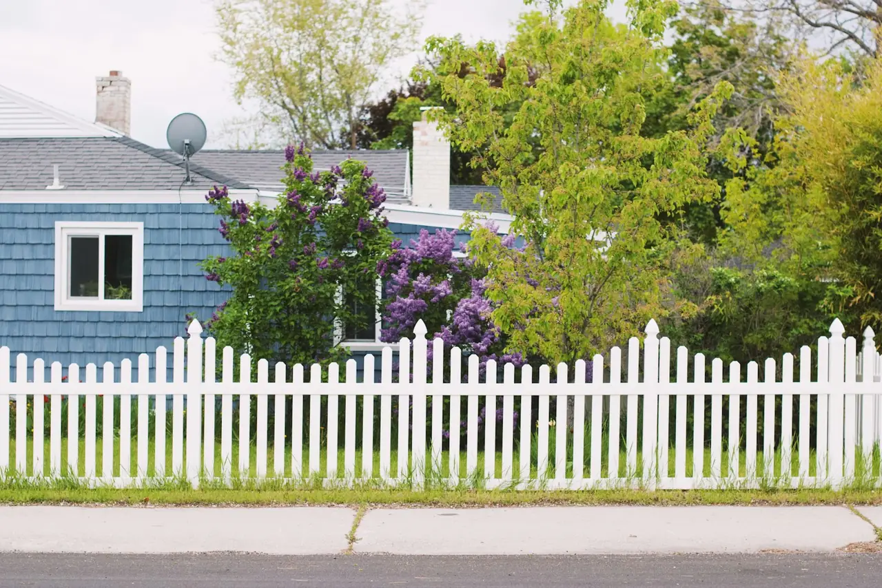 A white picket fence in front of a house
