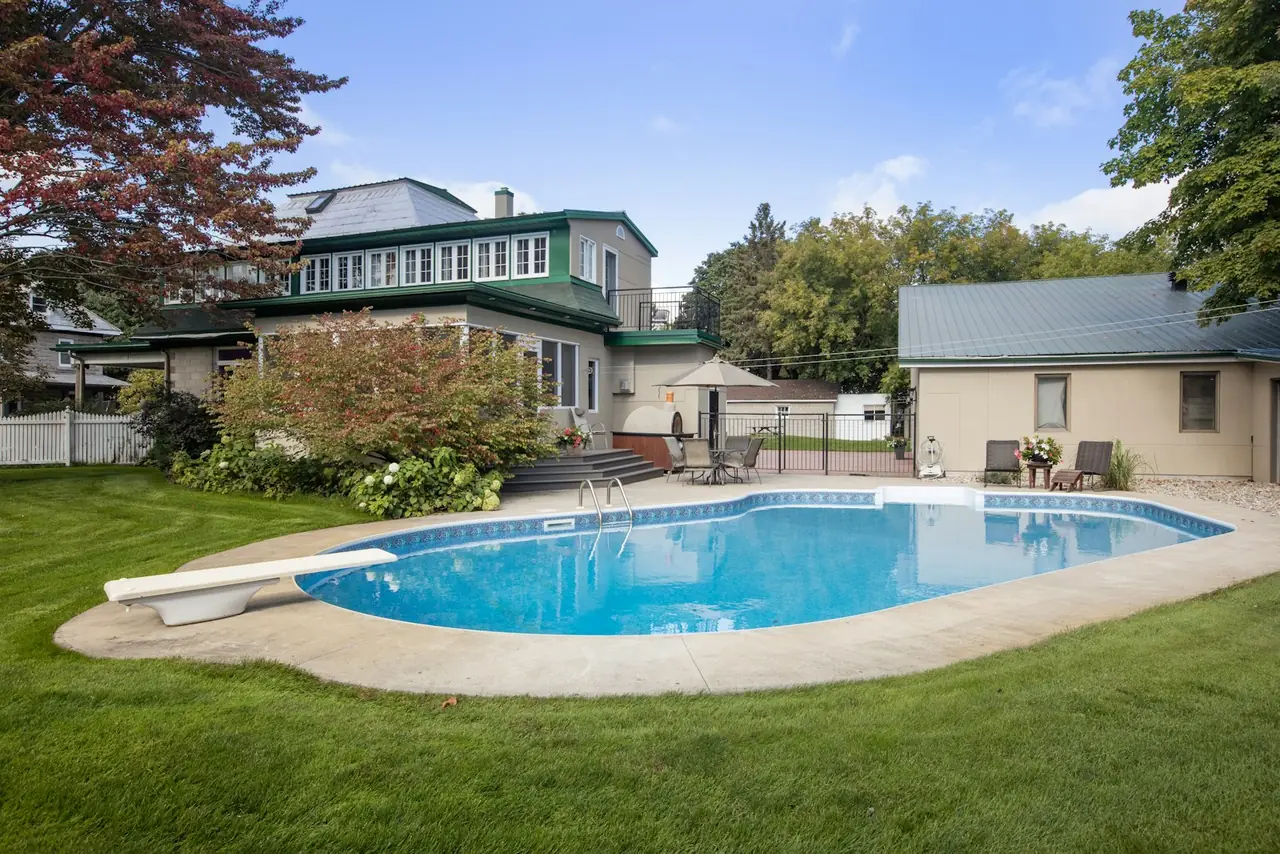 A backyard pool beside a house